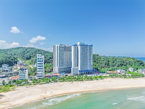 Un hôtel situé sur la côte, composé de plusieurs immeubles de grande hauteur, offrant un accès direct à la plage et une vue sur l’océan.
