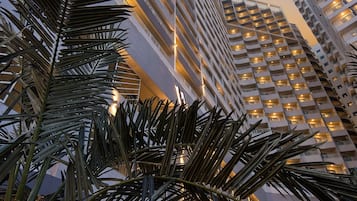 Um edifício alto com vários andares, janelas grandes e design arquitetônico moderno.