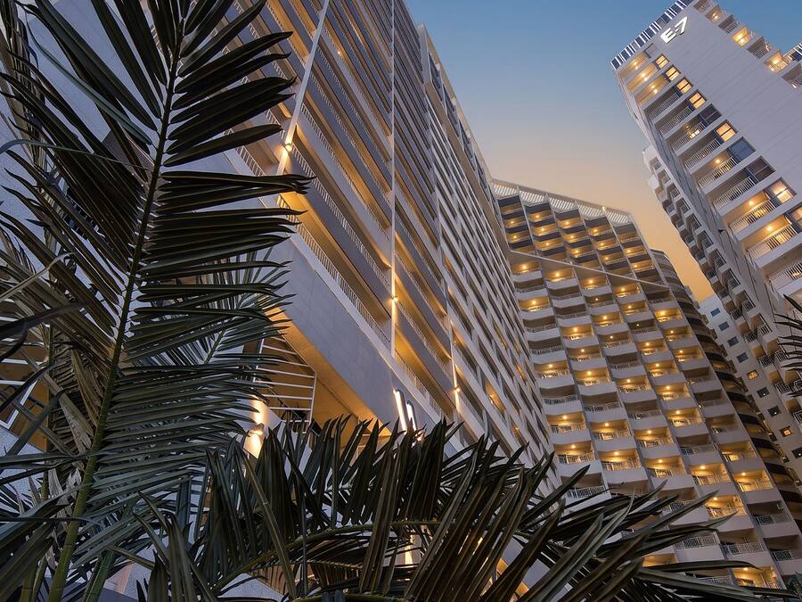 Un edificio de gran altura con varios pisos, ventanas amplias y un diseño arquitectónico moderno.