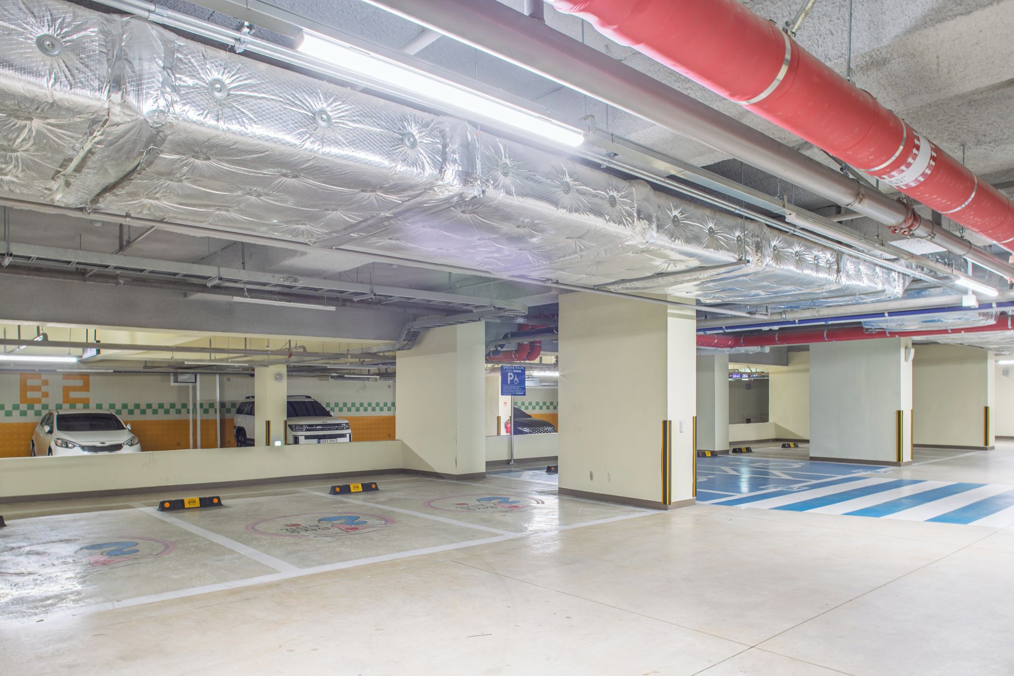 A parking garage with multiple levels, marked parking spaces, and visible structural elements like beams and columns.