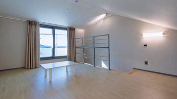 A room with a large window, a table, and a metal partition.