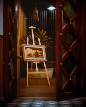 An easel with a framed painting in a hallway. - Avimukta An Ethnic Stay (Varanasi)