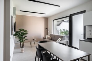 Un interno moderno con zona pranzo, divano e un'ampia finestra.