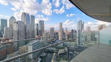 A high-rise building with a view of a city skyline, including several skyscrapers and a river.