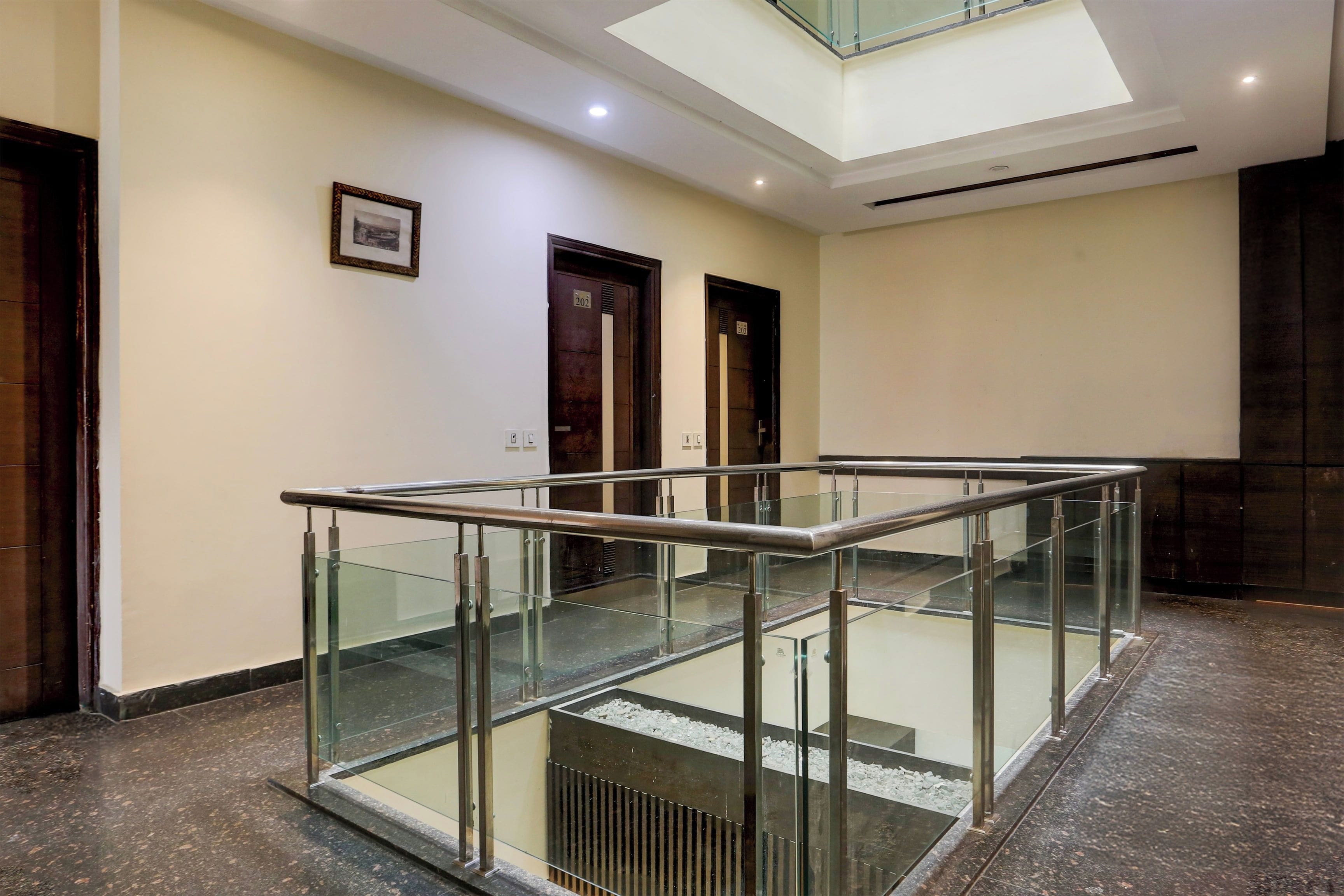 Un interior modern amb barana de vidre, un finestral i un disseny net i minimalista.