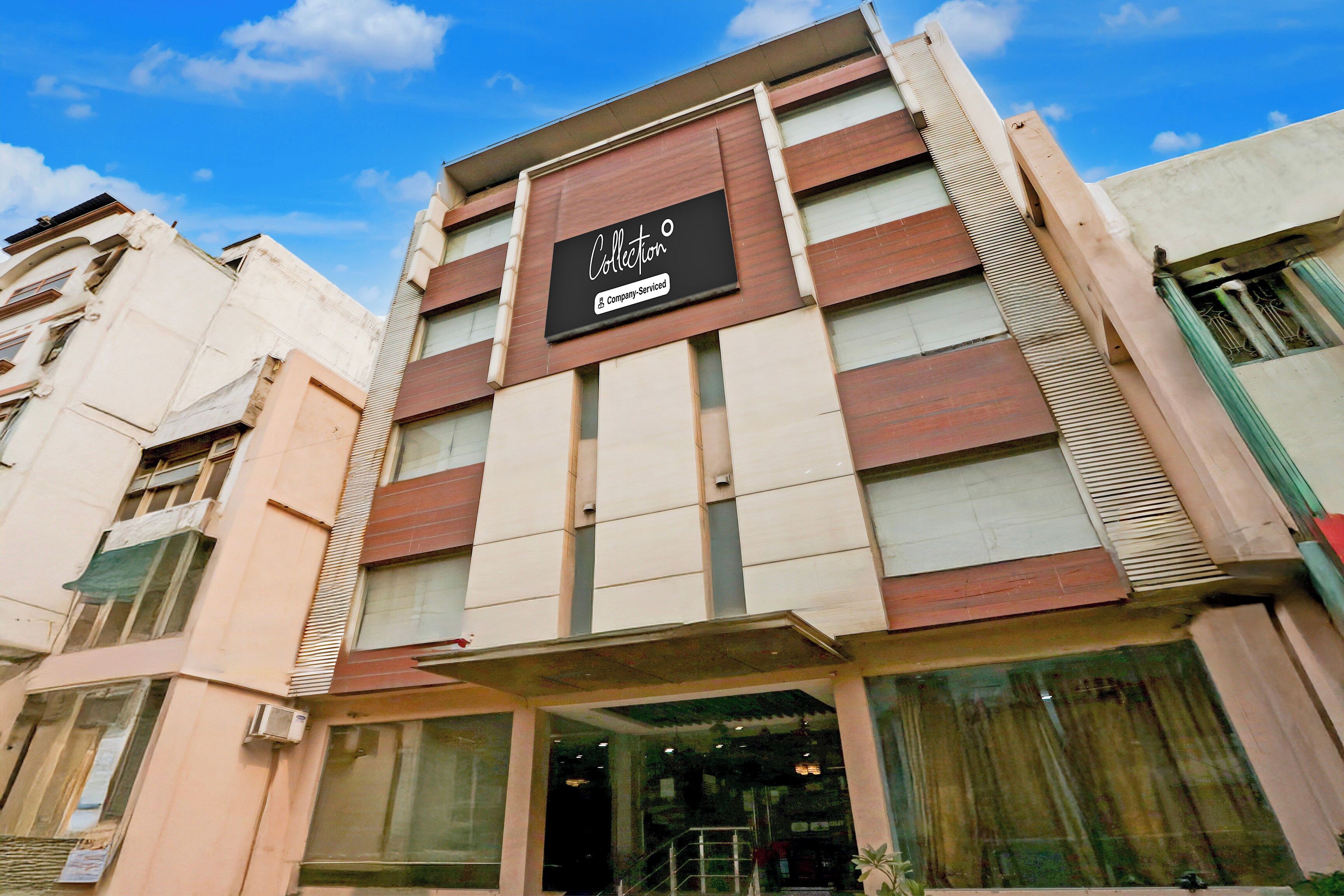 Un edificio de varios pisos con un letrero que dice 'Collection Company-Serviced'.