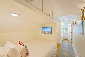 Ein Schlafzimmer mit Bett, Fernseher und Meerblick.