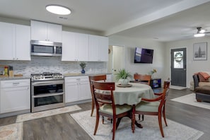 A modern kitchen with white cabinets, a built-in microwave, and a gas stove. - Recently Remodeled Dtwn Frisco Home w/ Yard! (Frisco)