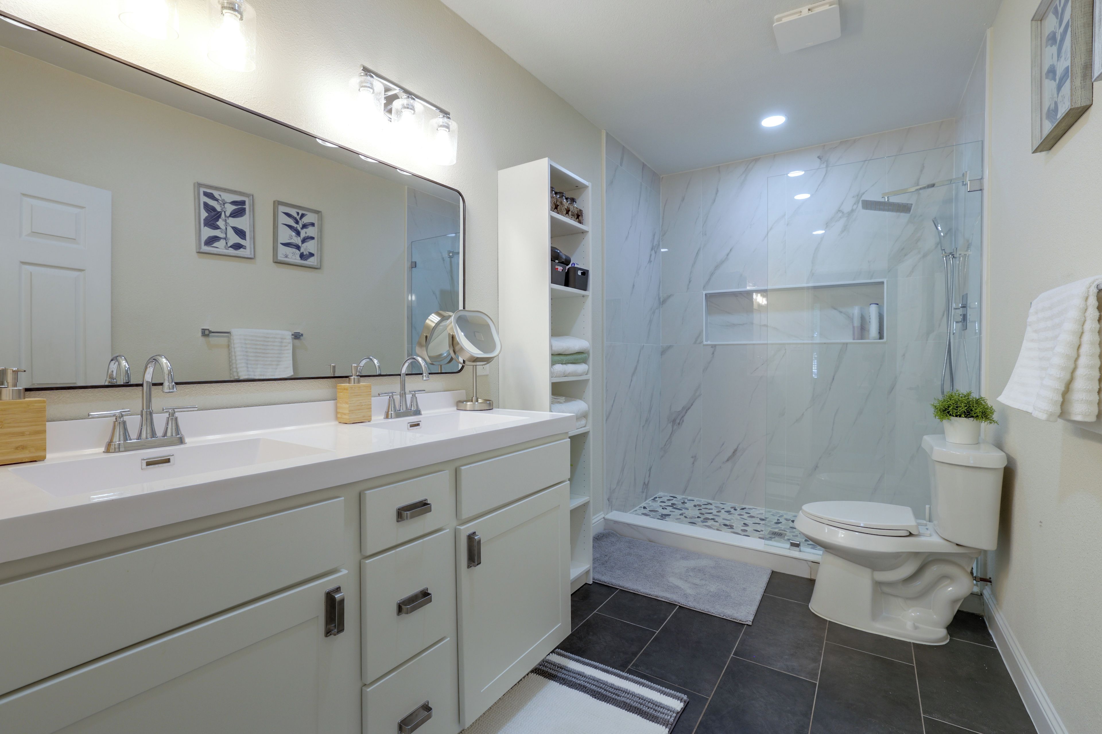 Un baño moderno con lavamanos doble, inodoro y zona de ducha.