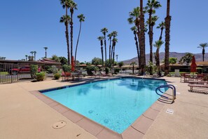 A swimming pool with a clear blue water, surrounded by palm trees and a mountain in the background. - Sunrise Country Club Condo w/ Pool & Tennis (Rancho Mirage)