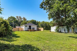 A residential backyard with a house, a wooden deck, and a fenced area. - Modern Retreat w/ Deck & Workspace Unit A (Cincinnati)