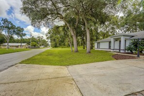 A residential street with houses, a sidewalk, and trees. - Near World Equestrian Ctr: Ocala Home w/ Yard (Ocala)