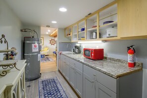 A kitchen with grey cabinets, a red microwave, and a fire extinguisher. - Puget Sound Views & Patio: Point No Point Apt (Hansville)