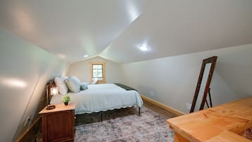 Un dormitorio con cama, mesita de noche, lámpara, ventana y espejo.