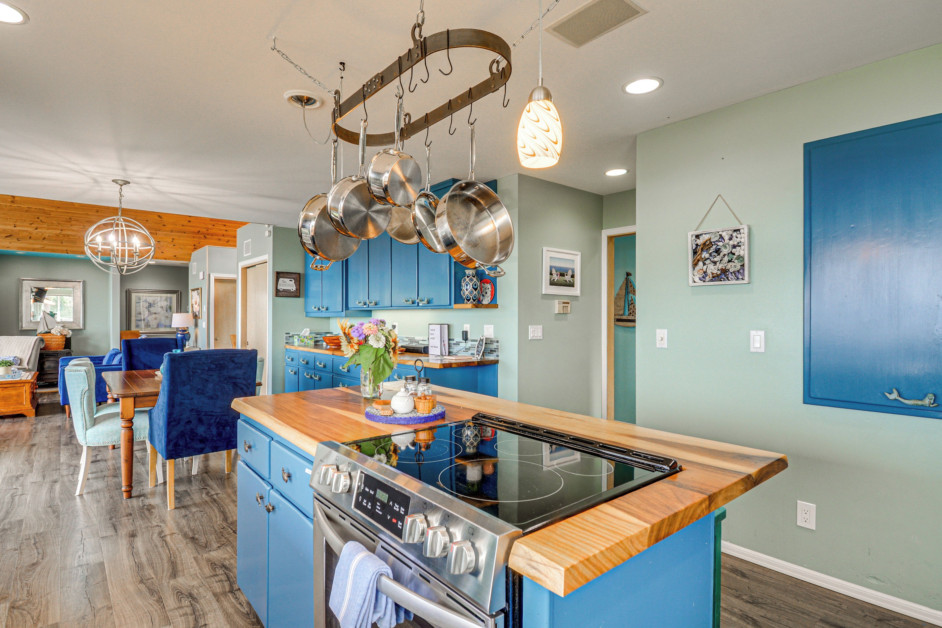 Una cucina moderna con mobili blu, un piano di lavoro in legno ed elettrodomestici in acciaio inossidabile.