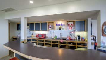 A modern kitchen with a curved island, built-in cabinets, and a variety of appliances.