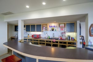 Cozinha moderna com ilha curva, armários embutidos e diversos eletrodomésticos.