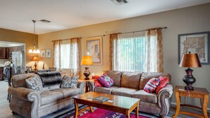 A living room with a sofa set, a coffee table, and a lamp. There is a kitchen in the background. - Desert-view Green Valley Retreat Near Golf Courses (Green Valley)