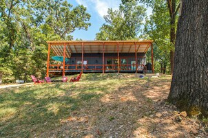 A cabin with a covered deck and outdoor seating area.