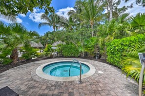 A circular pool with a metal ladder, surrounded by a brick pathway and lush tropical vegetation. - Olé at Lely Resort, More Than a Vacation (Naples)