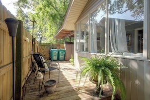 A wooden deck with a covered seating area, a potted plant, and a view of the house.