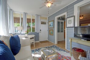 Uma sala de estar acolhedora com sofá, televisão e área de jantar com mesa e cadeiras.