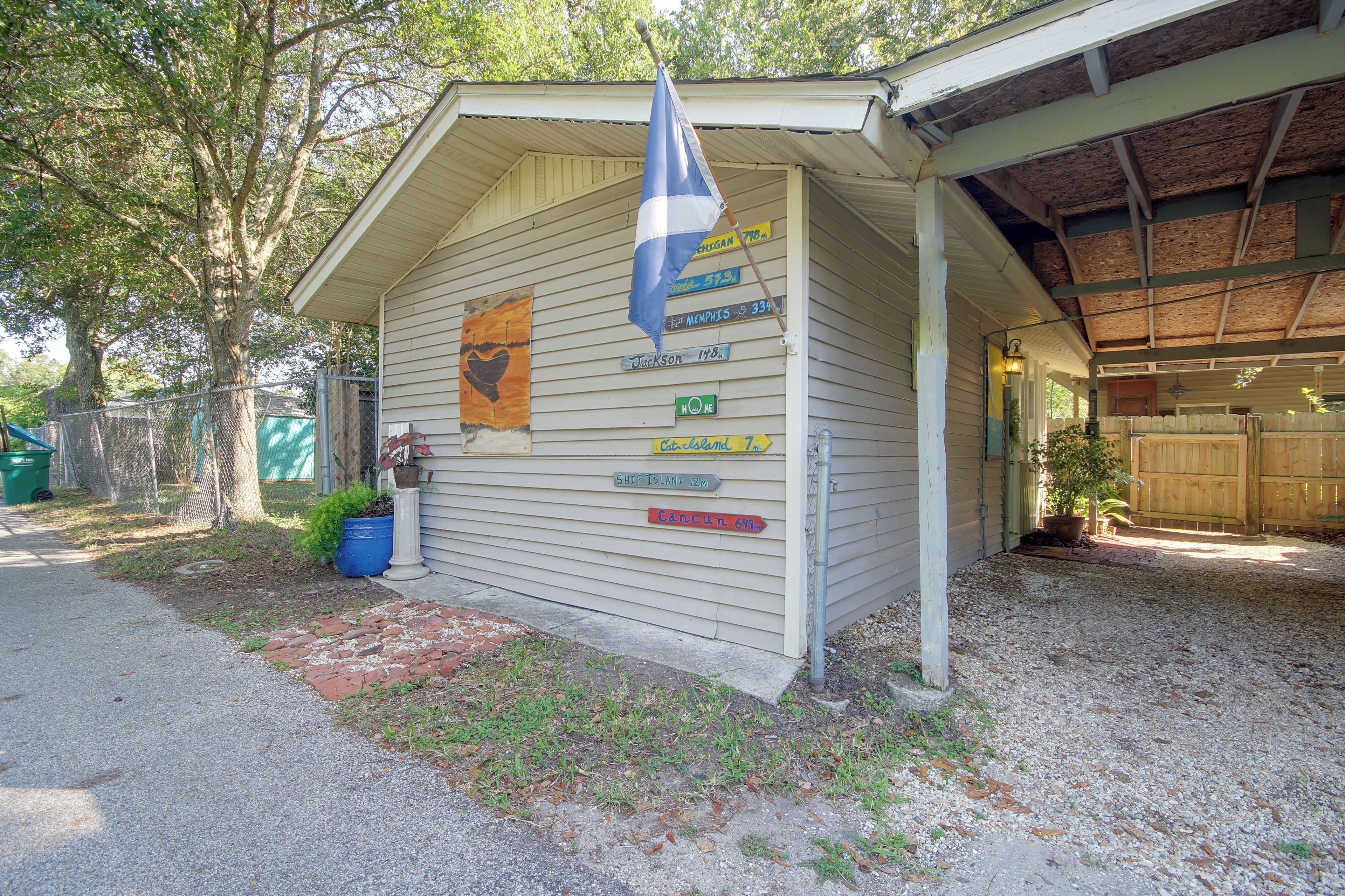 A building with multiple directional signs, a covered porch, and a fenced yard.