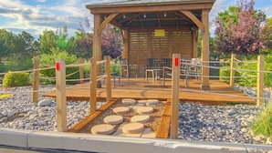 A wooden gazebo with a roof, surrounded by a rope fence, and featuring a seating area with benches and tables. - See the Royal Gorge! Cañon City Apartment (Canon City)