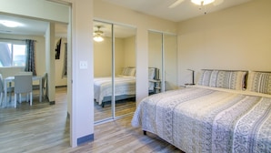 A bedroom with a bed, a desk, and a chair. There is a ceiling fan and a mirror. - See the Royal Gorge! Cañon City Apartment (Canon City)