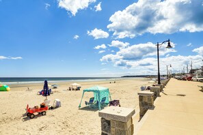 A beach with a clear sky, a sandy shore, and a row of beach umbrellas. - Sun, Surf & Seafood: York Home 2 Blocks to Beach (York Beach)