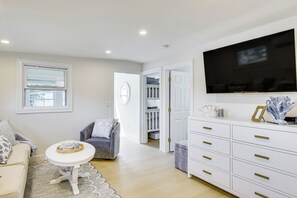 A modern living room with a flat-screen TV, a grey sofa, a white coffee table, and a white cabinet with drawers. - Sun, Surf & Seafood: York Home 2 Blocks to Beach (York Beach)