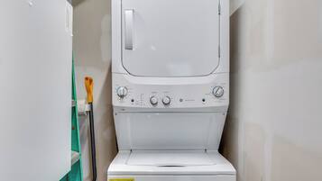 Una unidad compacta de lavadora y secadora con perillas de control y una etiqueta que indica una guía de eficiencia energética.