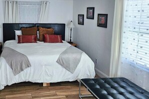 A neatly made bed with a headboard, a bedside lamp, and a small table. - 6 Mi to Beach! Sarasota Studio w/ Screened Porch (Sarasota)