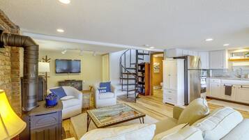A modern living room with a fireplace, a sofa, a coffee table, and a television.