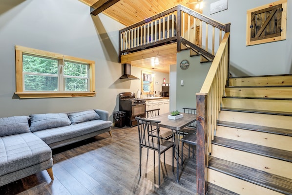 A cozy interior with a loft bedroom, a dining area, and a kitchen.