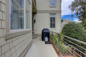 A residential building with a covered outdoor grill, a metal railing, and a well-maintained hedge. - 20 Knotts Way: North Forest Beach Retreat w/ Private Pool, Spa & Beach Access (Hilton Head Island)