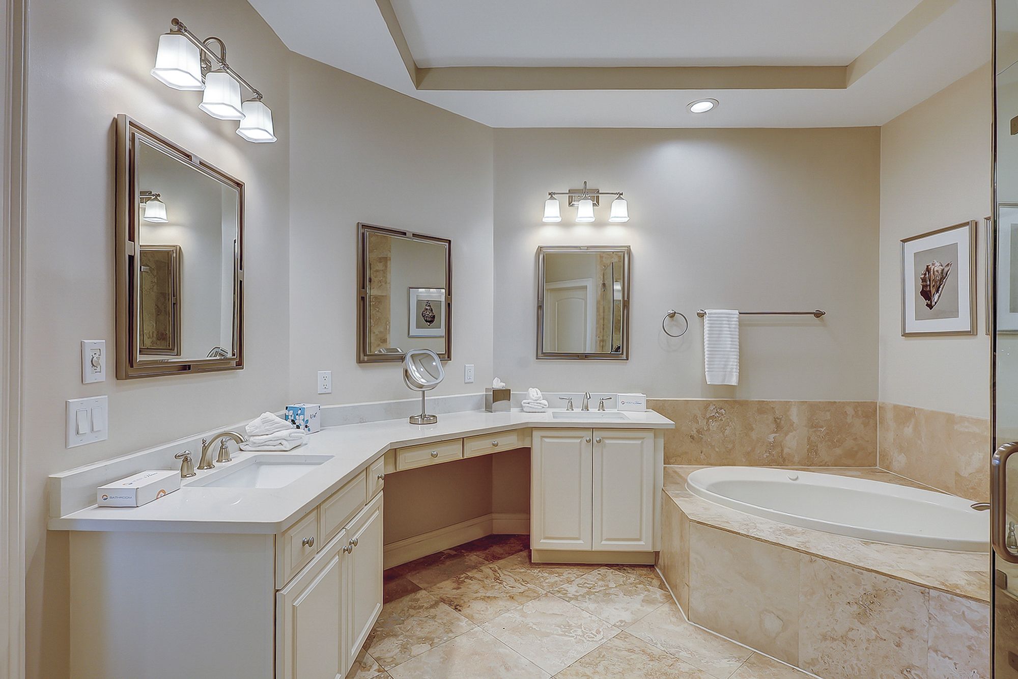 A modern bathroom with a large bathtub, a vanity with a mirror, and a shower area.