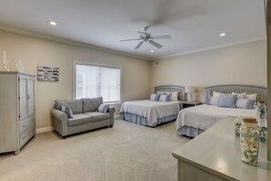 A bedroom with two beds, a sofa, a ceiling fan, and a cabinet. - 20 Knotts Way: North Forest Beach Retreat w/ Private Pool, Spa & Beach Access (Hilton Head Island)