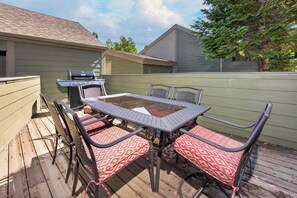 Eine Terrasse im Freien mit Tisch, Stühlen, einem Grill und einem Holzdeck.