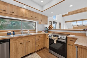 A modern kitchen with wooden cabinets, a stainless steel sink, and a built-in oven.