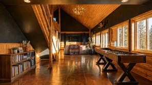 A spacious room with a wooden ceiling, a pool table, and a bookshelf. - The Chief's Cabin Tumalo 4BR Log Cabin with Cascade Views (Bend)