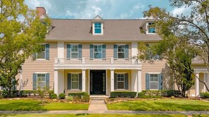 A two-story house with a front porch, a central entrance, and a small balcony. - Woodlands Haven Bright 3 BR Townhouse in Houston (Spring)