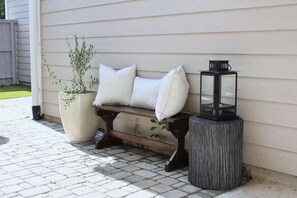 A bench with cushions and a potted plant beside a house. - Woodlands Haven Bright 3 BR Townhouse in Houston (Spring)