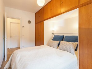 Ein Schlafzimmer mit einem Bett, einem Holzschrank und einer Tür.