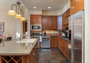A modern kitchen with granite countertops, stainless steel appliances, and wooden cabinets. - Slope View | King Beds | Ski in/Ski Out (Keystone)