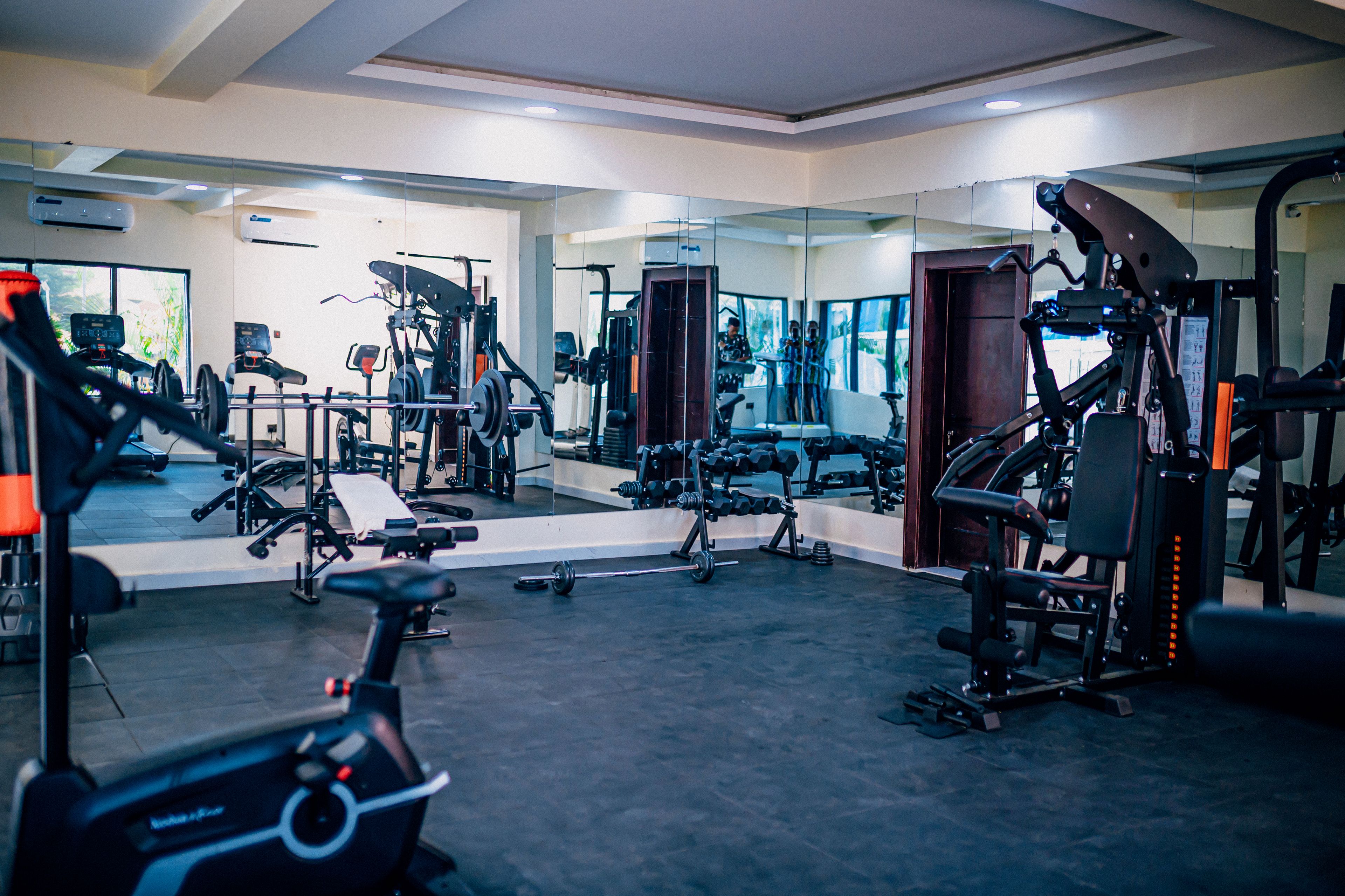 A gym with various exercise equipment, including treadmills, weight machines, and free weights.
