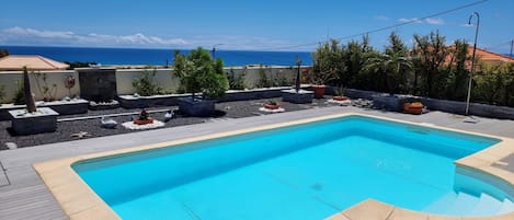 Piscina retangular com superfície de água azul límpida, cercada por um deck com borda clara.