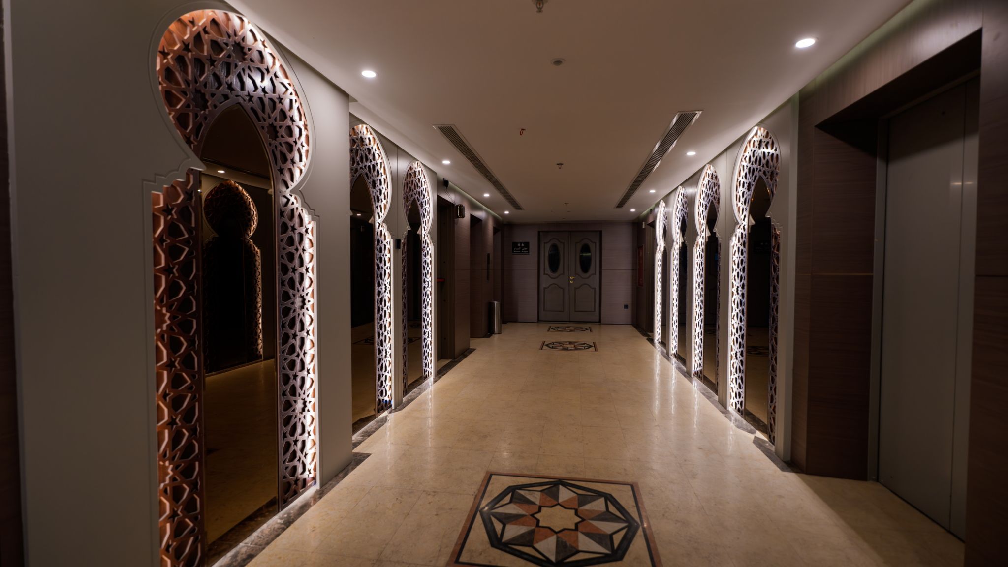A hallway with patterned walls and a geometric floor design.