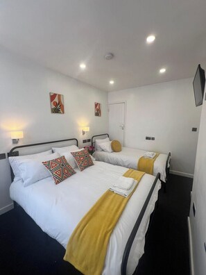 A hotel room with two beds, a flat-screen TV, and a door. - Florence House Sleeps 13 - Free Parking & Garden (West Bromwich)