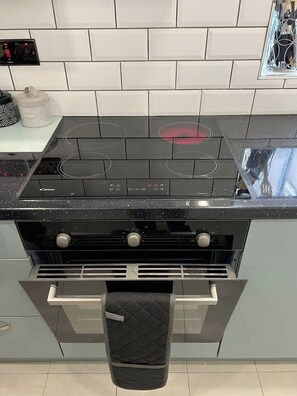 A kitchen with a black stovetop, a silver oven, and a black range hood. - Florence House Sleeps 13 - Free Parking & Garden (West Bromwich)